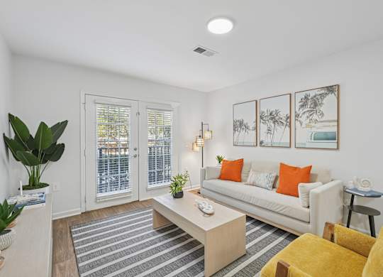 A living room with a white couch, a coffee table, and a striped rug.