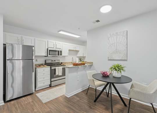 A kitchen with a refrigerator, oven, and sink.