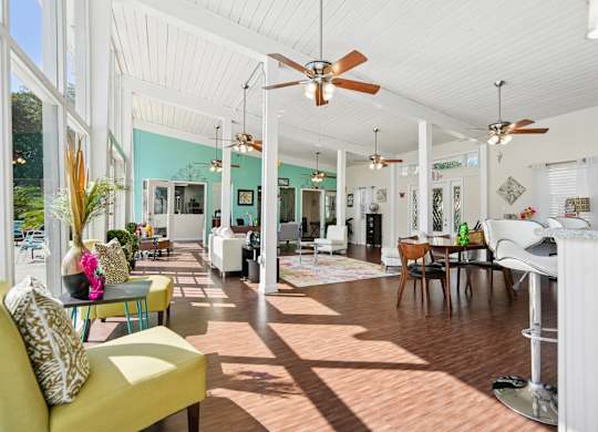 A sunny day in a spacious living room with a yellow sofa and a dining table.