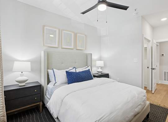 A bedroom with a large bed, a ceiling fan, and a nightstand with a lamp at Union Eleven Apartments, Atlanta, 30324