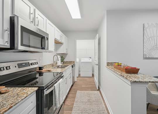 A kitchen with black appliances and white cabinets.