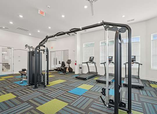 A gym with a variety of equipment including treadmills and weight machines.at The Parker Leland, North Carolina, 28451