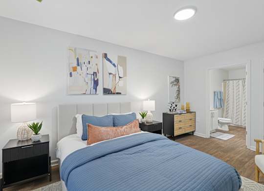 A bedroom with a large bed and a painting on the wall.