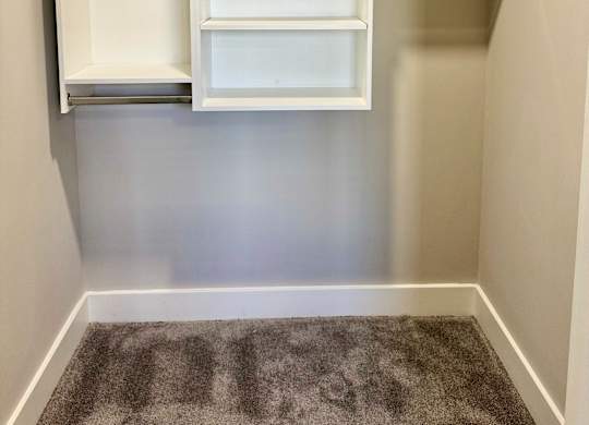 A white shelving unit with open shelves is mounted on a wall at The Collective Upper Westside Apartments, Georgia