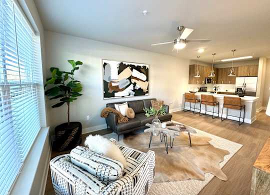 A living room with a couch, a coffee table, and a painting on the wall at The Collective Upper Westside Apartments, Atlanta, Georgia