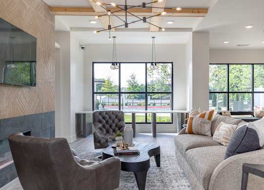A modern living room with a grey sofa, a black chair, and a coffee table at The Collective Upper Westside Apartments, Atlanta, GA
