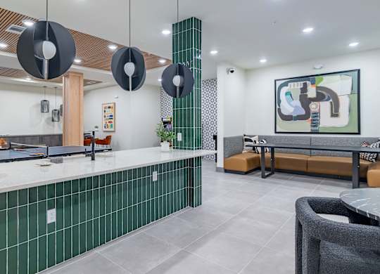 A modern kitchen with green tiled backsplash and a grey countertop at The Collective Upper Westside Apartments, Atlanta
