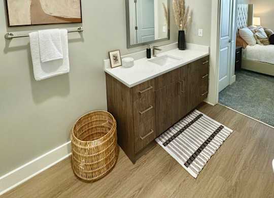 A bathroom with a wooden vanity and a mirror above it at The Collective Upper Westside Apartments, Atlanta, GA
