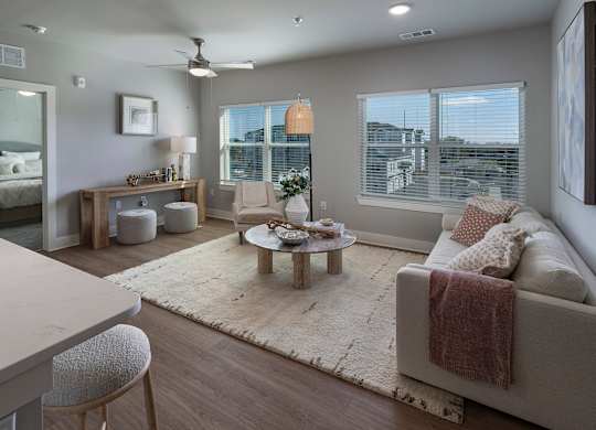 A well-lit, modern living room with a large couch and a coffee table at The Waverly at Winter Haven Apartments, Winter Haven, Florida