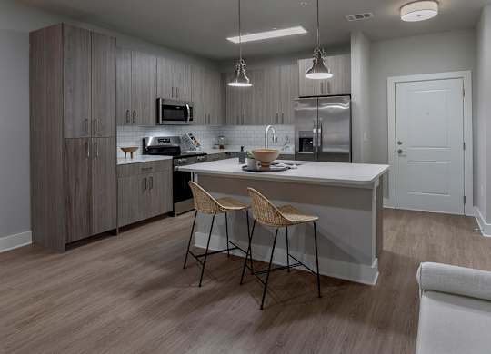 A modern kitchen with a dining table and chairs at The Waverly at Winter Haven Apartments, Winter Haven