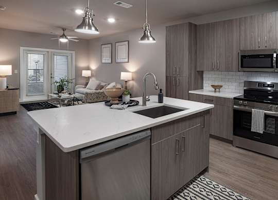 A modern kitchen with a large island and stainless steel appliances at The Waverly at Winter Haven Apartments, Winter Haven, FL, 33884