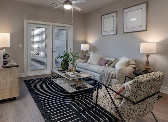 A living room with a couch, chair, and two lamps at The Waverly at Winter Haven Apartments, Winter Haven, FL
