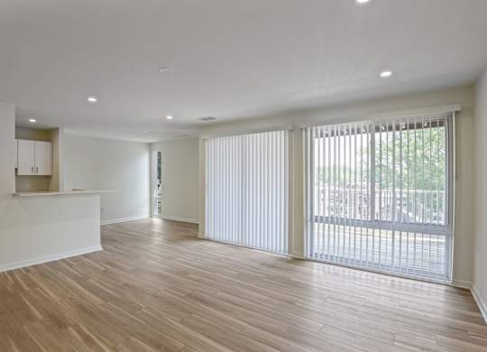 A large empty room with wooden floors and white walls.