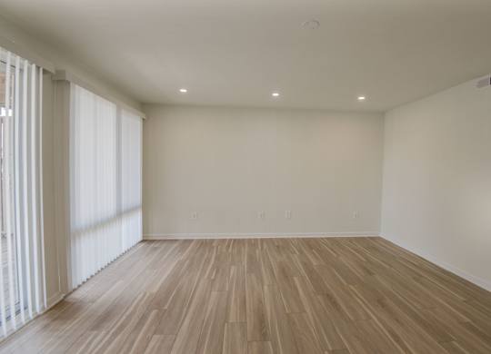 A room with wooden flooring and white walls.