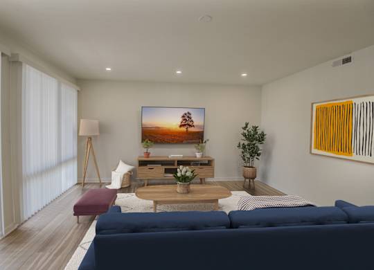 A modern living room with a blue sofa and a flat screen TV mounted on the wall.