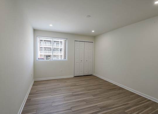 A room with a wooden floor and a window.