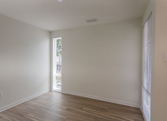 A room with wooden flooring and a window.
