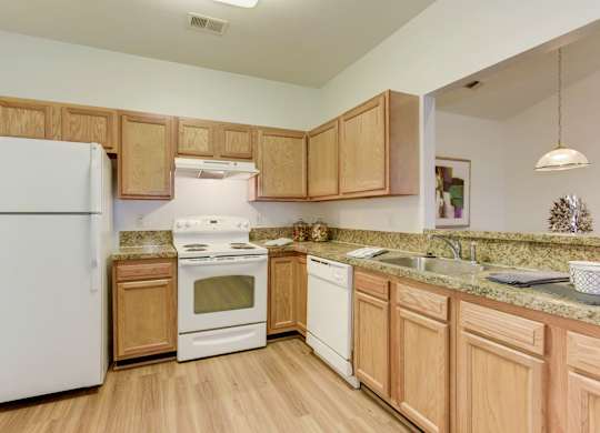 a kitchen with white appliances and wooden cabinets