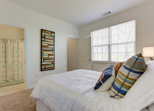 a bedroom with a bed and two windows