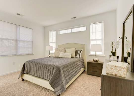 a bedroom with a bed and two windows