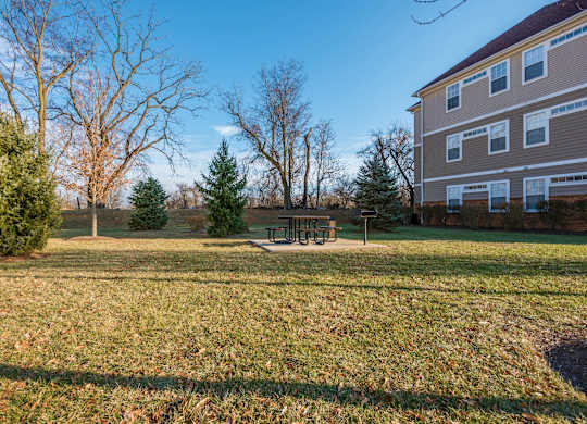 a yard with a picnic table in front of a house