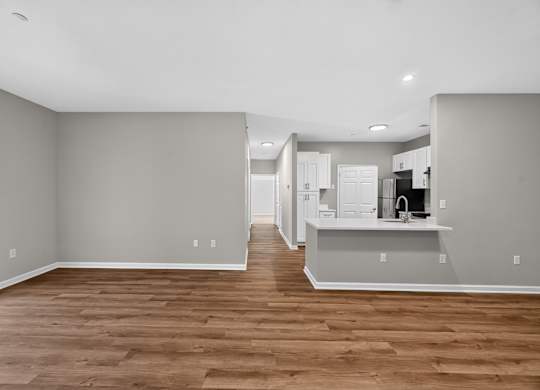 A kitchen with a refrigerator, sink, and cabinets.