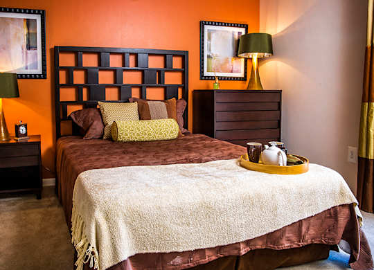 A bedroom with a bed, nightstands, and lamps.
