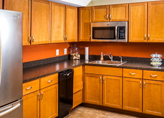 A kitchen with wooden cabinets and a black countertop.