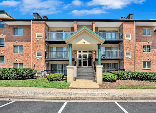 A large brick building with a balcony and a small entrance.