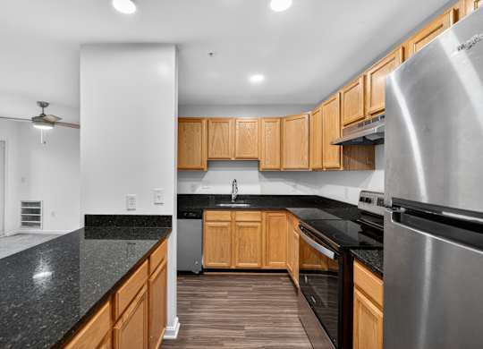 A modern kitchen with wooden cabinets and stainless steel appliances.