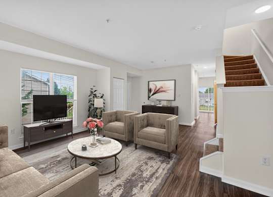 A living room with a grey sofa, a white coffee table, and a brown armchair.