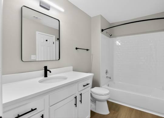 A white bathroom with a sink, toilet, and bathtub.