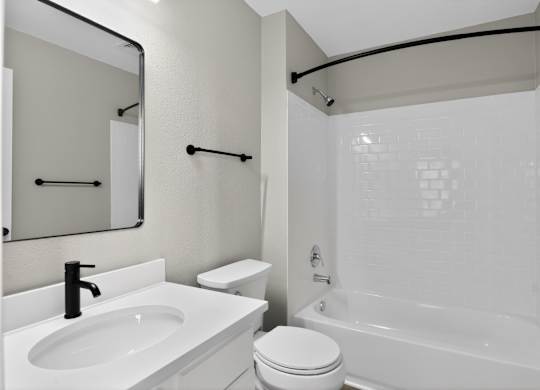 A white bathroom with a sink, toilet, and bathtub.