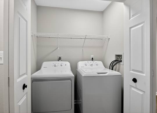 A small bathroom with a sink and a washer and dryer.