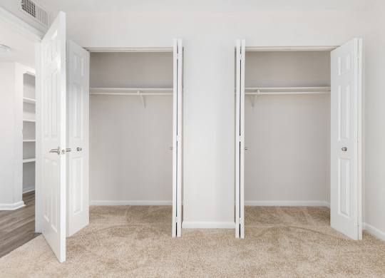 Two white closet doors with shelves inside.