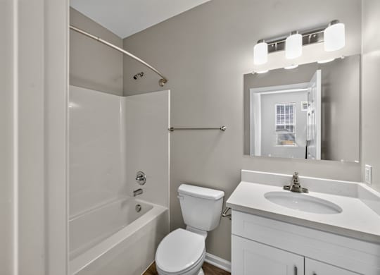 A white bathroom with a toilet, sink, and bathtub.