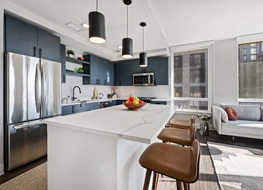 A modern kitchen with a white island and brown bar stools.