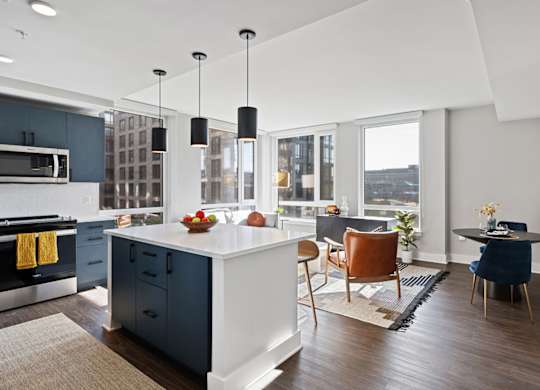 A modern kitchen with a large island and a dining area.