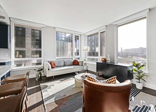 A living room with a brown leather chair and a white couch.