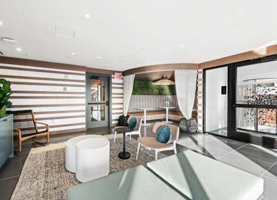 A modern living room with a striped wallpaper and a glass door leading to a balcony.