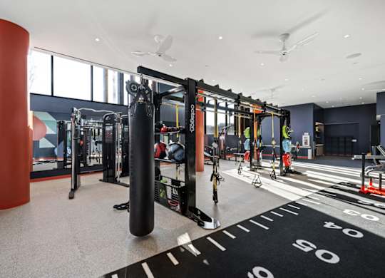 A gym with a variety of equipment including a punching bag.