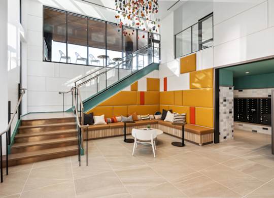 A staircase with a metal railing and a bench with cushions.