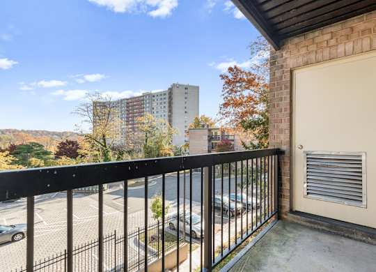 A balcony with a black railing and a white door.
