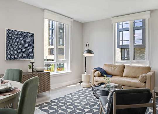 A living room with a couch, chairs, and a table.