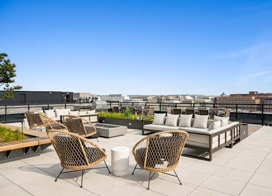 A patio with chairs and a table overlooking a cityscape.