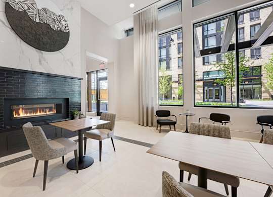 A modern dining room with a fireplace and a view of the city.
