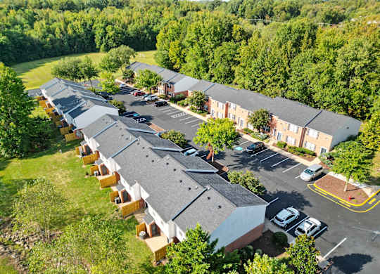 A row of houses with a parking lot in front.