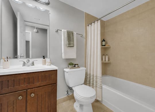 A white toilet sits in a bathroom next to a white sink.