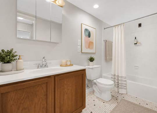 A bathroom with a white toilet, a white sink, and a white bathtub.