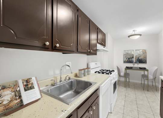 A kitchen with brown cabinets and a white sink.